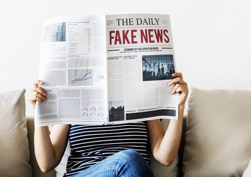 person reading fake news in the newspaper