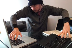Tim surrounded by 3 laptops